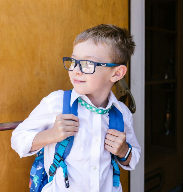 child with backpack looking to the left of the image